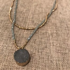 Gold and blue beaded necklace with stone charm